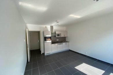 Pièce principale du studio de 32m2 situé Rue du Traité de Rome à Louvain-la-Neuve qui comprend 2 grandes fenêtres.